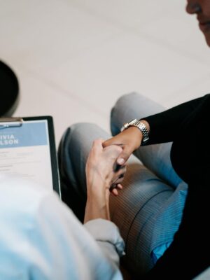 Two professional women having a handshake in an office setting, focusing on recruitment and connection.
